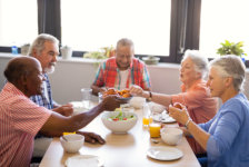 Senior men giving food to friends