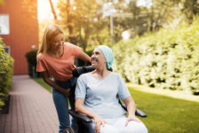 A woman with cancer is sitting in a wheelchair