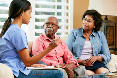 nurse and elderly couple talking